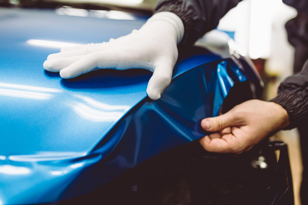 Detailing specialist installing a vinyl wrap on a car in South Florida
